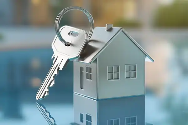 Symbolisches Miniaturhaus mit eingestecktem Schlüssel als Darstellung für schlüsselfertiges Bauen