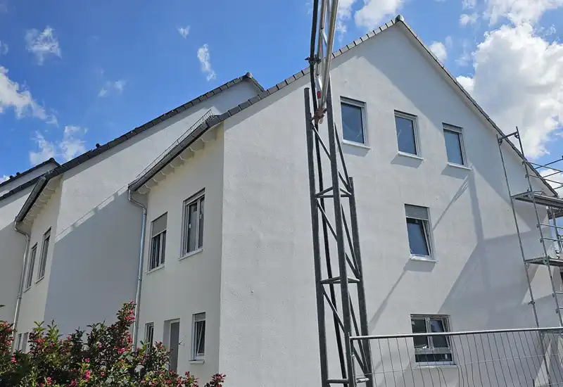 Baustelle mit Kran und Rohbau eines Mehrfamilienhauses